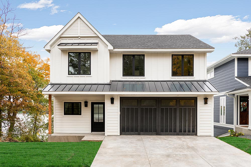 Two-story lakefront home exterior with white siding and three-car garage