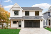 Two-story lakefront home exterior with white siding and three-car garage